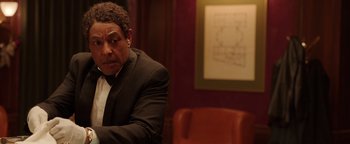 Movie still from “Kaleidoscope” (2023), directed by Mairzee Almas – A man in a suit sitting in front of a whiteboard; Close Up shot, Over the shoulder angle