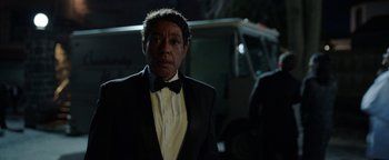 Movie still from “Kaleidoscope” (2023), directed by Mairzee Almas – A man in a tuxedo standing in front of a fire truck at night; Close Up shot, Over the shoulder angle