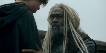 Movie still from “House of the Dragon” (2022), created by George R.R. Martin – A man with dreadlocks talking to a child; Close Up shot, Over the shoulder angle