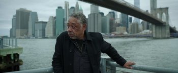 Movie still from “Kaleidoscope” (2023), directed by Mairzee Almas – An older man leaning on a railing near a body of water; Close Up shot, Over the shoulder angle