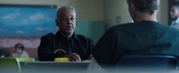 Movie still from “Kaleidoscope” (2023), directed by Mairzee Almas – An older man sitting at a table in a room; Close Up shot, Over the shoulder angle