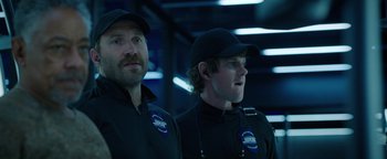 Movie still from “Kaleidoscope” (2023), directed by Mairzee Almas – A couple of men standing next to each other in a room; Close Up shot, Low angle