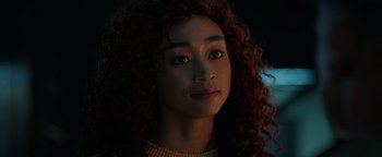 Movie still from “Kaleidoscope” (2023), directed by Mairzee Almas – A person with curly red hair; Close Up shot, Over the shoulder angle