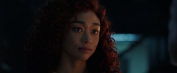 Movie still from “Kaleidoscope” (2023), directed by Mairzee Almas – A person with curly red hair; Close Up shot, Over the shoulder angle