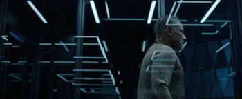 Movie still from “Kaleidoscope” (2023), directed by Mairzee Almas – A man standing in front of a wall of lights; Medium shot, Low angle