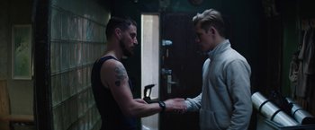 Movie still from “Kidnapping Stella” (2019), directed by Thomas Sieben – Two men are shaking hands in a dark room; Medium shot, Over the shoulder angle