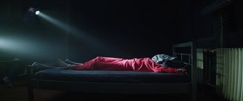Movie still from “Kidnapping Stella” (2019), directed by Thomas Sieben – A person is sleeping on a bed in a dark room; Wide shot, High angle