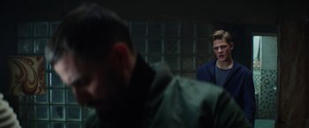 Movie still from “Kidnapping Stella” (2019), directed by Thomas Sieben – A man standing in front of another man in front of a brick wall; Medium shot, Over the shoulder angle