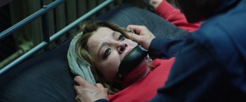 Movie still from “Kidnapping Stella” (2019), directed by Thomas Sieben – A woman is taped to her face while lying in a bed; Close Up shot, High angle
