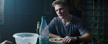 Movie still from “Kidnapping Stella” (2019), directed by Thomas Sieben – A man sitting at a table with a plate of food; Close Up shot, Over the shoulder angle