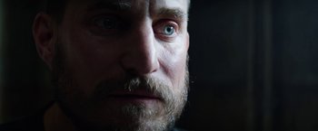 Movie still from “Kidnapping Stella” (2019), directed by Thomas Sieben – A man with a beard and blue eyes; Close Up shot, Low angle