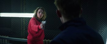 Movie still from “Kidnapping Stella” (2019), directed by Thomas Sieben – A woman holding a gun in front of a mirror; Medium shot, Over the shoulder angle