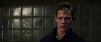 Movie still from “Kidnapping Stella” (2019), directed by Thomas Sieben – A young man in front of a glass window; Close Up shot, Low angle