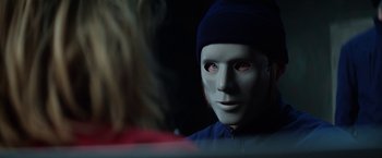 Movie still from “Kidnapping Stella” (2019), directed by Thomas Sieben – A person with a white mask and a blue hat; Close Up shot, Over the shoulder angle