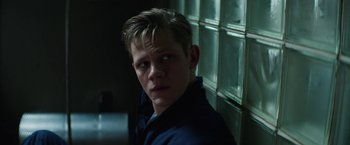 Movie still from “Kidnapping Stella” (2019), directed by Thomas Sieben – A young man in a blue shirt is looking at the camera; Close Up shot, Over the shoulder angle