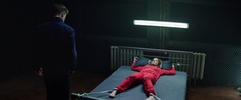 Movie still from “Kidnapping Stella” (2019), directed by Thomas Sieben – A girl in a red suit lying on a bed; Wide shot, High angle