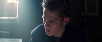 Movie still from “Kidnapping Stella” (2019), directed by Thomas Sieben – A young man looking into the distance in a dimly - lit room; Close Up shot, Low angle