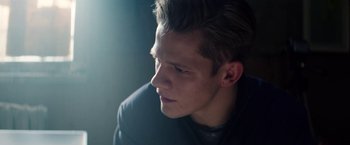 Movie still from “Kidnapping Stella” (2019), directed by Thomas Sieben – A young man looking down while sitting in a room; Close Up shot, Over the shoulder angle