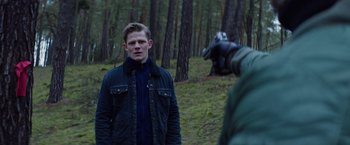 Movie still from “Kidnapping Stella” (2019), directed by Thomas Sieben – A man standing in the middle of a forest; Medium shot, Over the shoulder angle