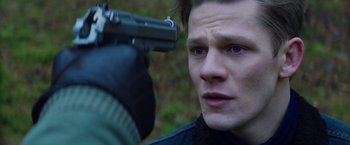 Movie still from “Kidnapping Stella” (2019), directed by Thomas Sieben – A man holding a gun up to his face; Close Up shot, High angle