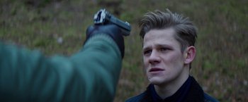 Movie still from “Kidnapping Stella” (2019), directed by Thomas Sieben – A man holding a gun up to his face; Close Up shot, Over the shoulder angle