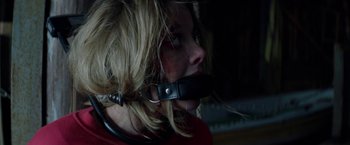Movie still from “Kidnapping Stella” (2019), directed by Thomas Sieben – A woman with a leather strap around her mouth; Close Up shot, Over the shoulder angle