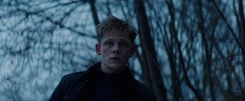 Movie still from “Kidnapping Stella” (2019), directed by Thomas Sieben – A young man in a black jacket in the woods; Close Up shot, Low angle