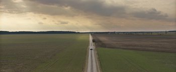 Movie still from “Kidnapping Stella” (2019), directed by Thomas Sieben – An aerial view of a car driving down a rural road; Extreme Wide shot, High angle