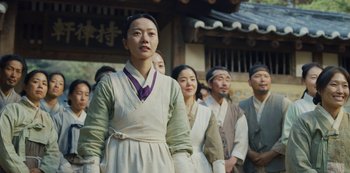 Movie still from “Kingdom” (2019), created by Eun-hee Kim – A group of people standing next to each other in front of a building; Medium shot, Low angle