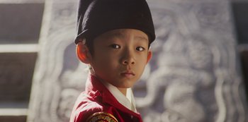 Movie still from “Kingdom” (2019), created by Eun-hee Kim – A young boy wearing a black hat and a red jacket; Close Up shot, High angle