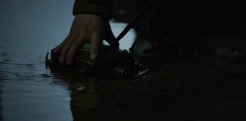 Movie still from “Kingdom” (2019), created by Eun-hee Kim – A person holding a knife in a puddle of water; Extreme Close Up shot, High angle