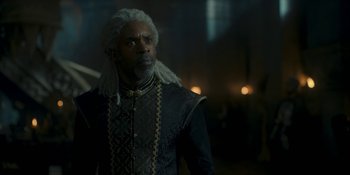Movie still from “House of the Dragon” (2022), created by George R.R. Martin – A man with long white hair and a black outfit; Medium shot, Over the shoulder angle