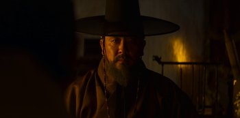 Movie still from “Kingdom” (2019), created by Eun-hee Kim – A man with a long beard wearing a hat; Close Up shot, Low angle