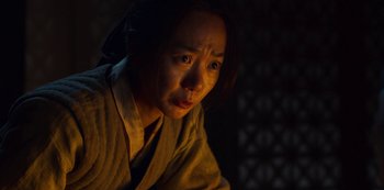 Movie still from “Kingdom” (2019), created by Eun-hee Kim – A woman in a robe looking at the camera; Close Up shot, High angle