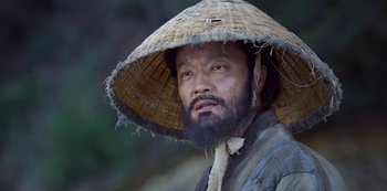 A man wearing a straw hat and a beard