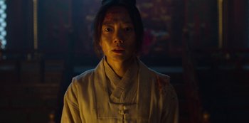 Movie still from “Kingdom” (2019), created by Eun-hee Kim – A woman in a white shirt is looking at the camera; Close Up shot, Low angle