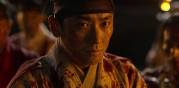Movie still from “Kingdom” (2019), created by Eun-hee Kim – A person wearing a hat; Close Up shot, Low angle