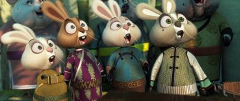 Movie still from “Kung Fu Panda 3” (2016), directed by Jennifer Yuh Nelson – A group of three cartoon rabbits standing next to each other on a table; Medium shot, Low angle
