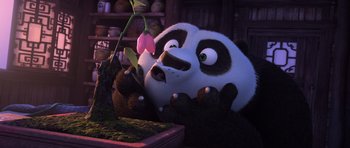 Movie still from “Kung Fu Panda 3” (2016), directed by Jennifer Yuh Nelson – A panda bear is holding a flower in his hands; Close Up shot, High angle