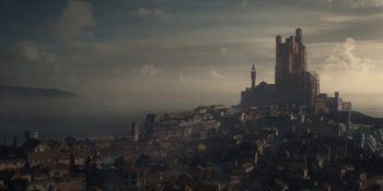 Movie still from “House of the Dragon” (2022), created by George R.R. Martin – A view of a town with a castle in the background; Extreme Wide shot, High angle