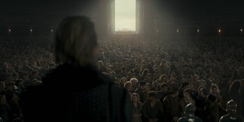 Movie still from “House of the Dragon” (2022), created by George R.R. Martin – A crowd of people standing in front of an open door; Extreme Wide shot, High angle