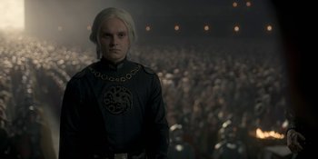 Movie still from “House of the Dragon” (2022), created by George R.R. Martin – A man with blonde hair wearing a black shirt; Medium shot, Over the shoulder angle