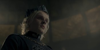 Movie still from “House of the Dragon” (2022), created by George R.R. Martin – A man with blonde hair wearing a crown; Close Up shot, Low angle