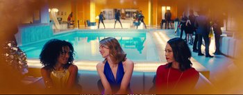 Movie still from “La La Land” (2016), directed by Damien Chazelle – Two women sitting next to each other in front of an indoor pool; Medium shot, Over the shoulder angle