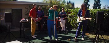 Movie still from “La La Land” (2016), directed by Damien Chazelle – A group of people standing around a microphone; Wide shot, High angle
