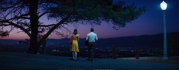 Movie still from “La La Land” (2016), directed by Damien Chazelle – A man and a woman standing on the side of a hill; Wide shot, Low angle