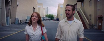 Movie still from “La La Land” (2016), directed by Damien Chazelle – A man and a woman walking down a street; Medium shot, Low angle