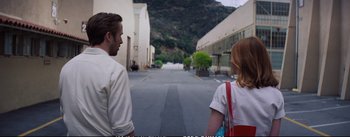 Movie still from “La La Land” (2016), directed by Damien Chazelle – A man and a woman walking down a street; Wide shot, Over the shoulder angle