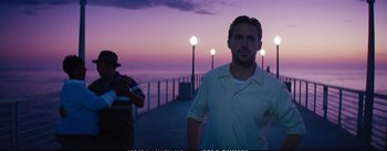 Movie still from “La La Land” (2016), directed by Damien Chazelle – A man standing on a pier at night with the ocean in the background; Medium shot, Over the shoulder angle