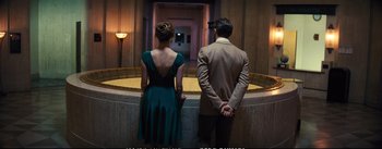 Movie still from “La La Land” (2016), directed by Damien Chazelle – A man and a woman standing next to each other in front of a fountain; Medium shot, High angle